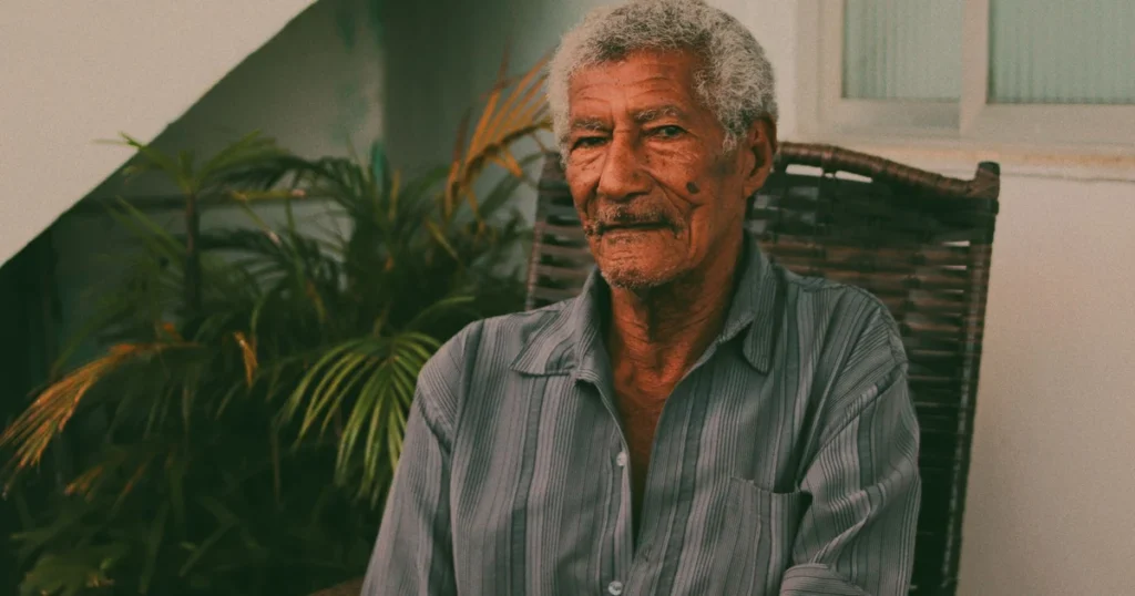 Retrato de um senhor idoso sentado em casa